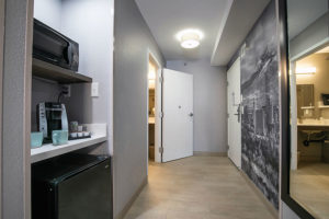 guest room interior hallway with amenity nook include a microwave, mini fridge, and coffee maker